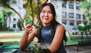 Woman smiling while eating lunch outside