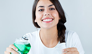Lady smiling and holding oral rinse