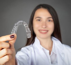 Woman holding Invisalign in Richardson