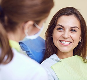 a smiling patient speaking with a dentist