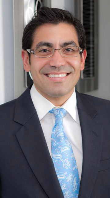 Dr. Javier Ortiz wearing suit smiling