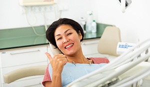 woman smiling and holding a thumbs up