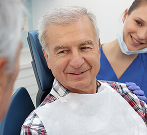 elderly man on dental chair smiling
