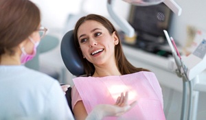 A female patient listens closely as her periodontist explains the need to replace one of her missing teeth with a dental implant
