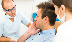 Dentist examing patient's cheek pain